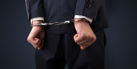 Dark backgrounded close handcuffed man