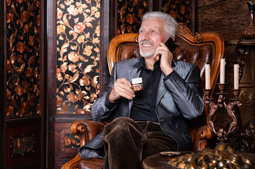  senior man drinking coffee and talking on phone 