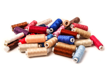 Colored bobbins isolated on white background. Colorful cotton yarns on rolls for sewing.