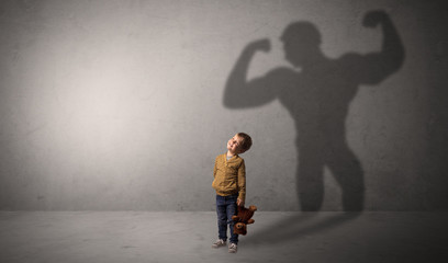 Muscleman shadow behind waggish little boy
