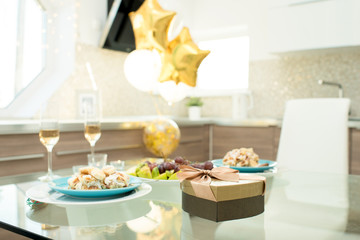 Background image of dinner table served  for romantic date on Valentines day in room decorated with balloons,  focus on heart shaped box of chocolates