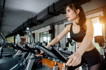 Fototapeta na wymiar Asian woman exercising in the gym, Young woman workout in fitness for her healthy and office girl lifestyle.