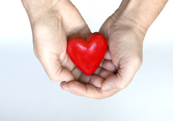 Obraz na płótnie Canvas Hands holding a red heart shaped Valentine figurine