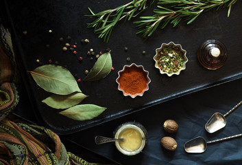 Various dry food spices and seasonings on a black pan