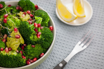 Healthy vegan food - broccoli salad with pomegranate and avocado souce