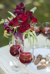 Chocolate truffles candys and glasses with red wine on white wooden table