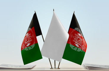 Two flags of Afghanistan with a white flag in the middle