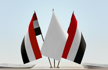 Two flags of Yemen with a white flag in the middle