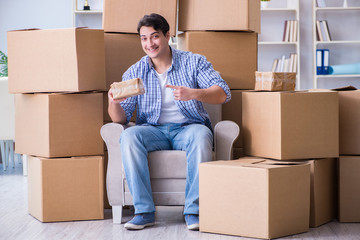 Young man moving in to new house with boxes