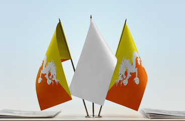 Two flags of Bhutan with a white flag in the middle