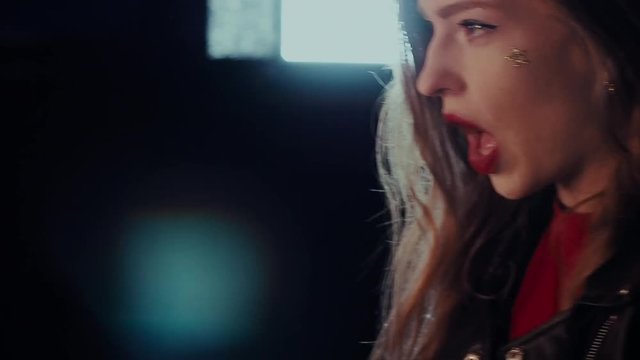 Attractive girl singing near the mirror. Portrait woman closeup. Steadicam