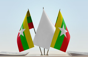 Two flags of Myanmar with a white flag in the middle