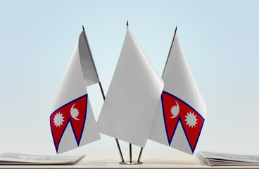Two flags of Nepal with a white flag in the middle