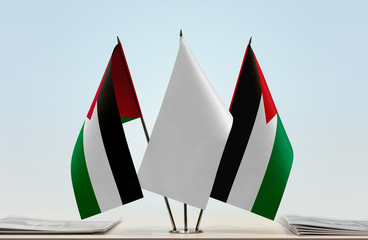 Two flags of Palestine with a white flag in the middle