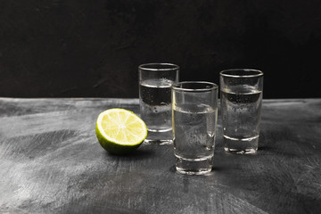 Cold vodka in shot glasses on a black background. Copy space. Food background