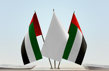 Two flags of UAE with a white flag in the middle