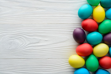 Multicolored Easter eggs on the wood table. Top view with copy space