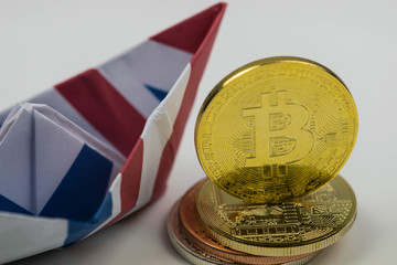 British flag boat with Extreme close up of Golden Bitcoin Coin Bitcoin cryptocurrency. Business concept.