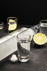 Cold vodka in shot glasses on a black background