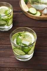 Detox drink with cucumber, lemon and mint in glasses on a wooden background