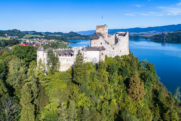 Fototapeta na wymiar Poland. Medieval Castle in Niedzica, built in 14th century, artificial Czorsztyn Lake and far view of the ruins of Czorsztyn castle, Aerial view in the morning