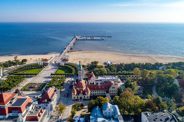 Sopot resort in Poland. SPA, old lighthouse, wooden pier (molo) with marina, yachts,  beach,  vacation infrastructure, park, promenade and walking people. Aerial view.