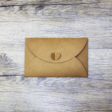 Brown craft envelope on wood background