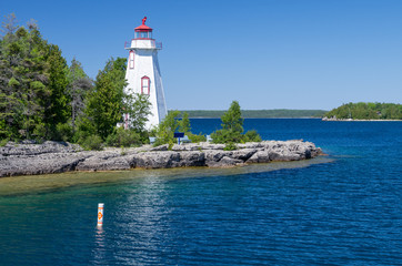 Small White Lighthouse Beside Deep Blue Waters