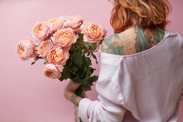 Girl holding a big bouquet of pink roses