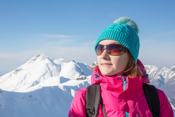 portrait of   young woman in sunglasses on background snowy mountain