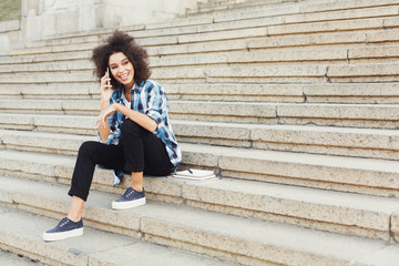 Obraz premium Young smiling woman talking on phone outdoors
