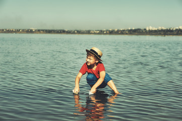 Boy playing in water with paper boats