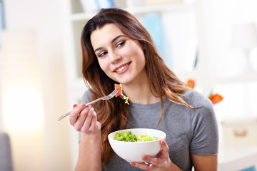 Woman eating healthy salad at home