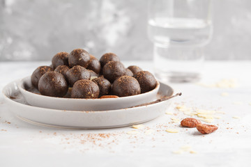 Vanilla-chocolate raw vegan sweet balls with nuts, dates and cocoa. Healthy vegan food concept. Gray background
