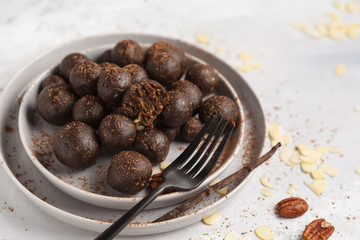 Vanilla-chocolate raw vegan sweet balls with nuts, dates and cocoa. Healthy vegan food concept. Gray background