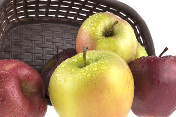wet, clean apples in a basket on a white background