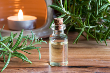 A bottle of rosemary essential oil with fresh rosemary twigs