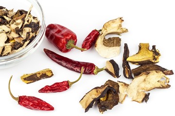 Dried mushrooms and chili peppers on a white background. Aromatic food ingredient. Traditional processing of mushrooms.