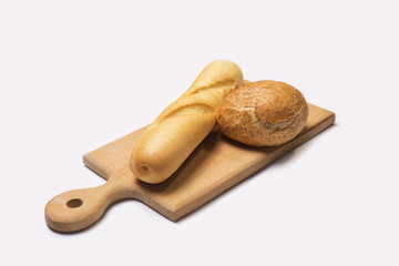 Freshly baked baguette homemade and rounded crispy bun on a wooden board isolated on white