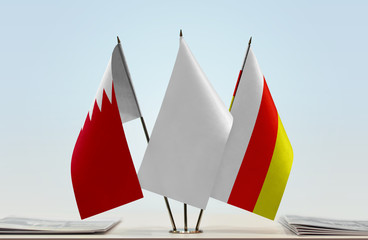 Flags of Bahrain and South Ossetia with a white flag in the middle