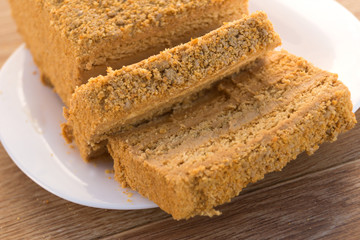 Traditional Russian baked honey cake, sliced on white plate