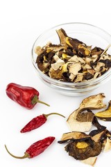 Dried mushrooms and chili peppers on a white background. Aromatic food ingredient. Traditional processing of mushrooms.