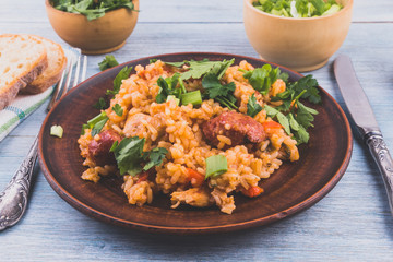 Jambalaya - rice, chicken and smoked sausage on rustic wooden background