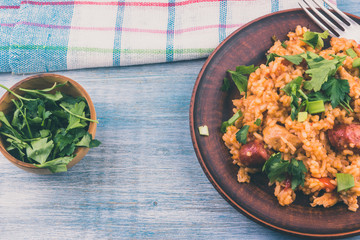 Jambalaya - rice, chicken and smoked sausage on rustic wooden background