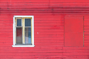 White wooden window on a red wooden house wall