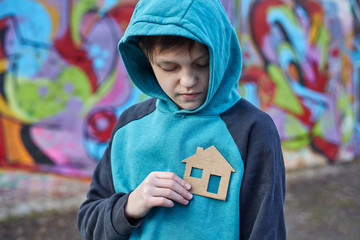homeless boy holding a cardboard house