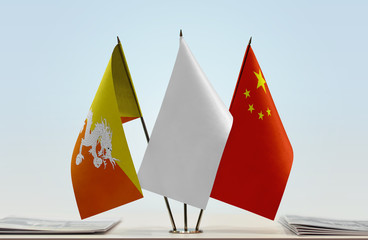 Flags of Bhutan and China with a white flag in the middle