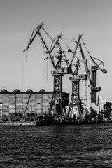 Gdansk shipyard, Poland. Retro style black and white. Cranes, old shipyard buildings, rusty structures.