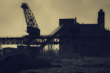 Fototapeta na wymiar Cranes, old shipyard buildings, rusty structures. Factory building.