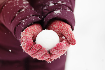 Close up of woman holding the snowball in hands, winter concept with copy space
